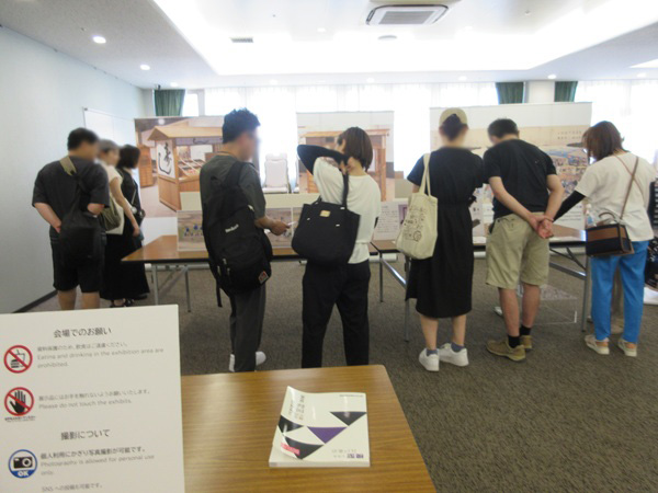 8人の人が「江戸の商業」に関する資料を見ている写真